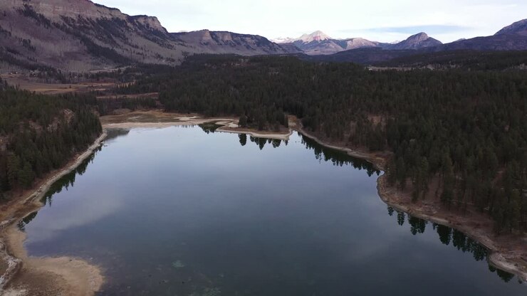 4K Drone going down to lake and reveal mountains