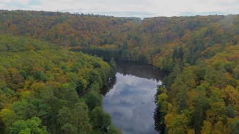 a view from above of the river that flows through the woods, which have become beautifully colored during autumn