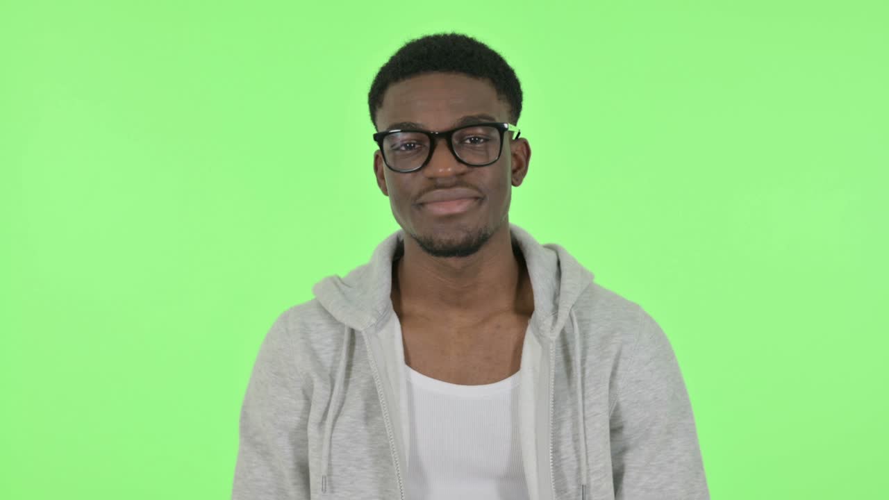 Afrikansk mand viser "okay"-tegn på grøn baggrund