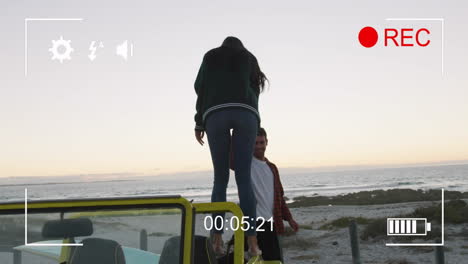 standing on car, woman enjoying beach view with timer animation overlay