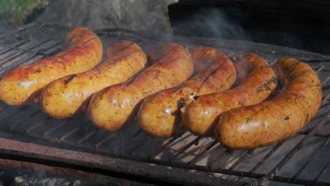 deliciosas salchichas jugosas, cocinadas en la parrilla con un fuego.