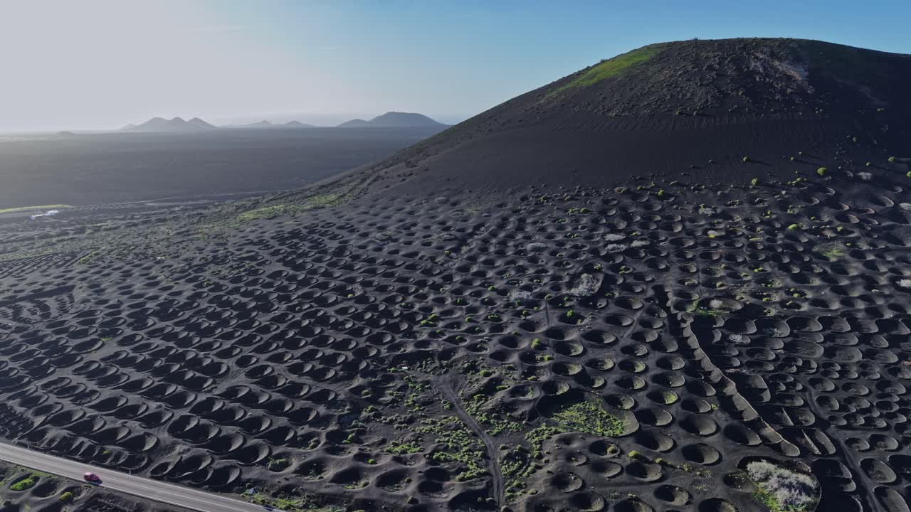 Vulkanlandskab med vinmarker på Lanzarote, Spanien ved solnedgang