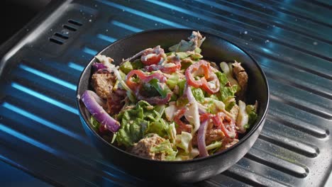 Static-shot-of-a-finished-tuna-salad-in-a-bowl-place-on-a-metal-surface