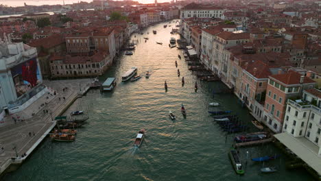 busy river of grand canal with water bus and gondola boats traveling in venice, italy