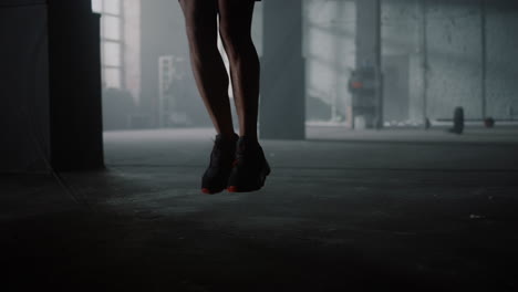 closeup unrecognizable man legs jumping on skipping rope in sport club