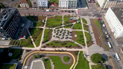 aerial sobre el parque centralny en gdynia, polonia, revelando un impresionante parque de la ciudad rodeado de tráfico