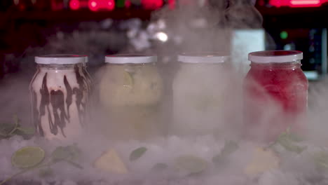 Smoke-Reveal-Of-Colourful-Frozen-Smoothie-Jars-On-Bar