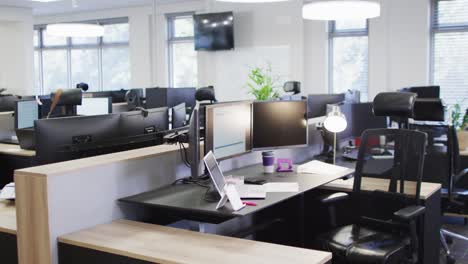 General-view-of-empty-modern-office-with-multiple-computers,-slow-motion