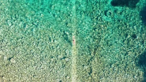 Woman-swimming-breaststroke-in-crystal-clear-turquoise-paradise-sea