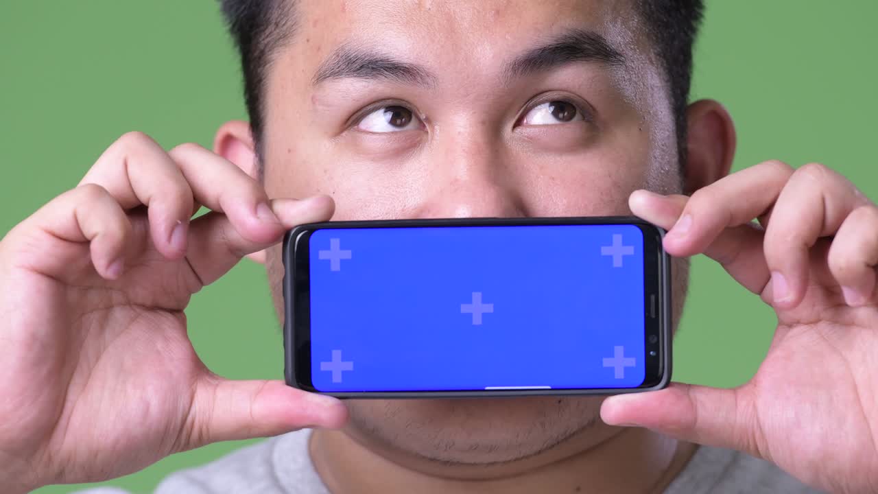 초록색 배경에 젊은 잘생긴 과체중 아시아인