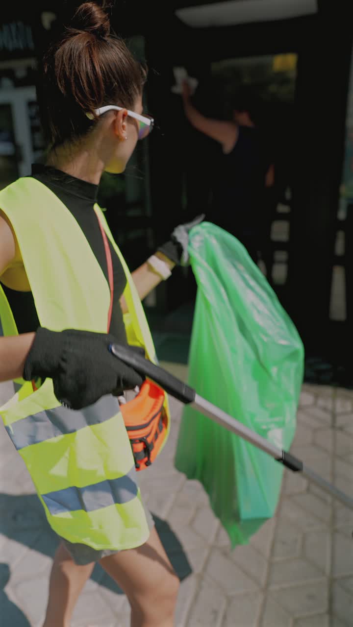 mujer limpiando la basura en la calle