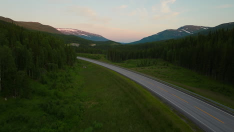 vehicles driving on highway e6 during midnight sun in northern norway