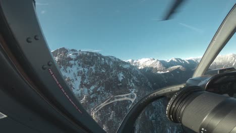 pov of a guy taking photos in the front seat of a helicopter in canada, bc