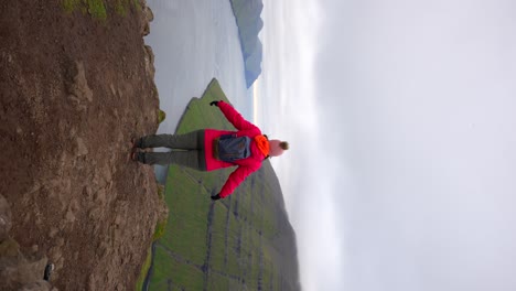 Mujer-Viajera-Libre-Levantando-Los-Brazos-En-La-Cima-De-La-Montaña-Klakkur-En-Klaksvik,-Islas-Feroe.