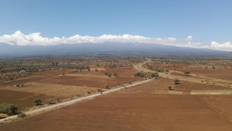 Jib-up-of-car-driving-over-dirt-road-in-rural-Africa