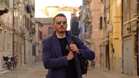 man talks and puts smartphone into coat pocket on street