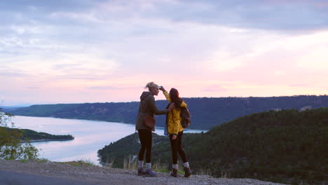 amigos tomando fotos de la puesta de sol sobre el lago