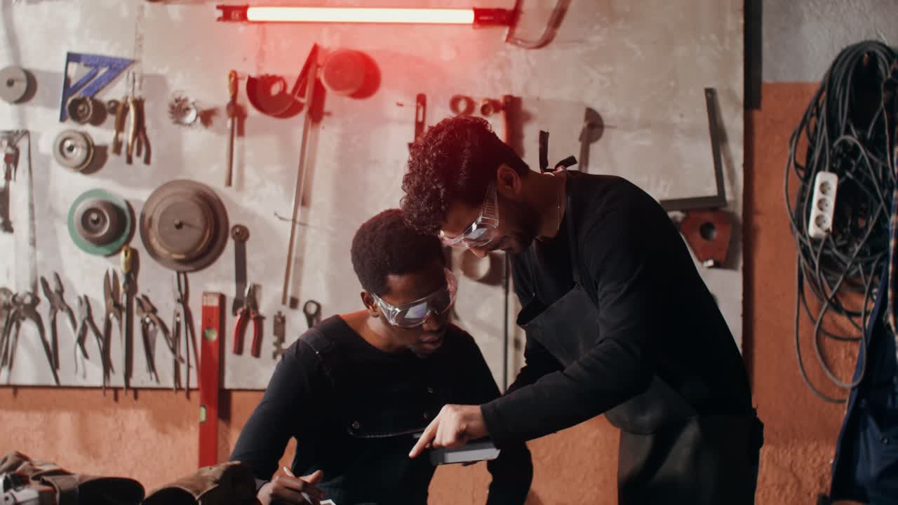 dos hombres colaborando en un proyecto de metalurgia en un taller