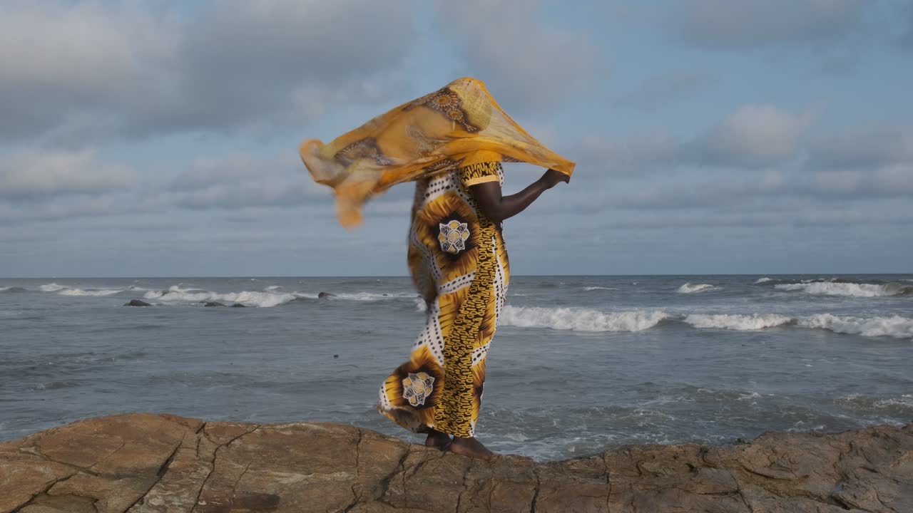 una mujer africana camina por los acantilados.