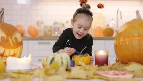 Happy-girl-painting-pumpkin