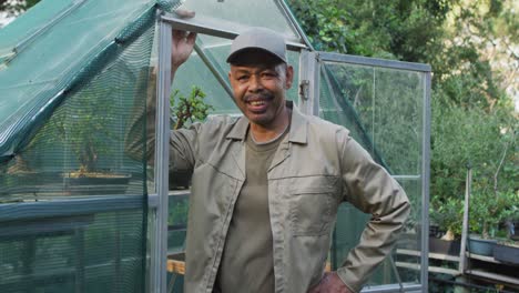 african american male gardener looking at camera and smiling at garden center