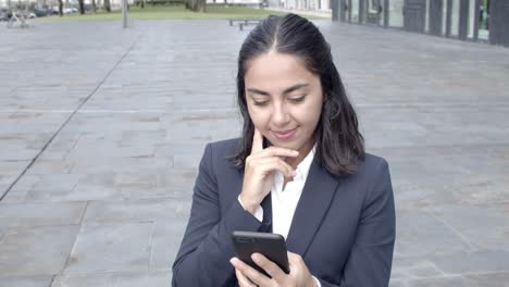 joven mujer de negocios usando un teléfono inteligente y sonriendo