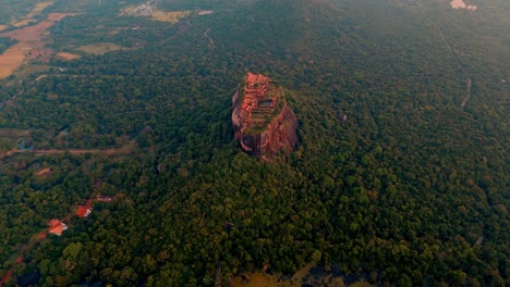 stunning orbiting drone footage circling around sigiriya rock fortress at sunrise in sri lanka.