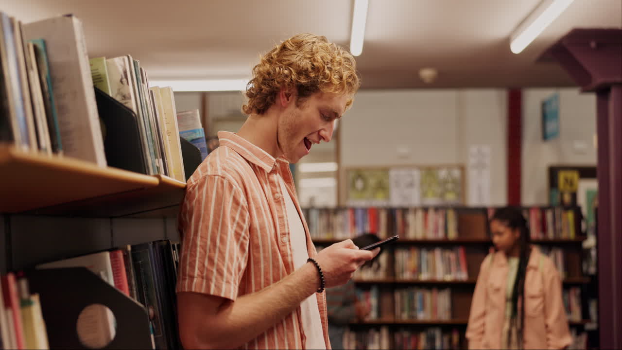 Ragazzo che usa il telefono in biblioteca