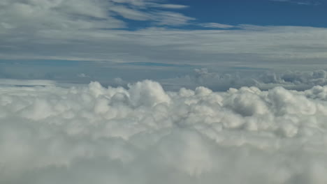 a spectacular view from the airplane window with clouds passing by and blue skies