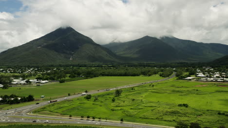 空中拍攝顯示澳洲農村道路上的交通,背景是茂密的山脈