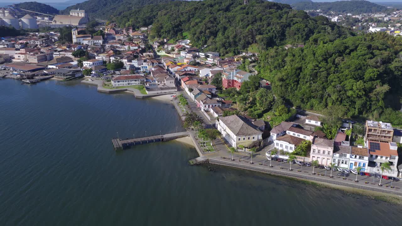 High-altitude panorama aerial view of Sao Francisco do Sul port side with pier and hillside community, Santa Catarina, Brazil