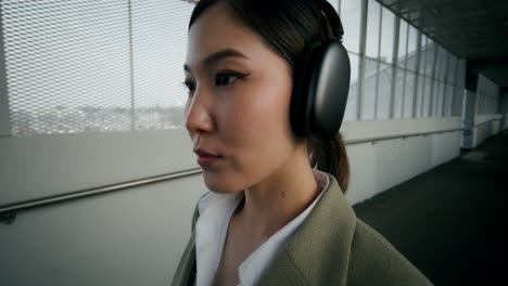 woman wearing headphones walking in a city