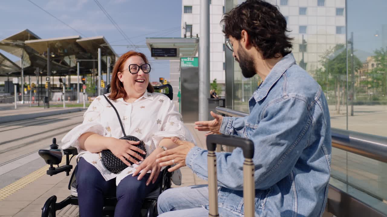 A woman in a wheelchair and a man at a transit station