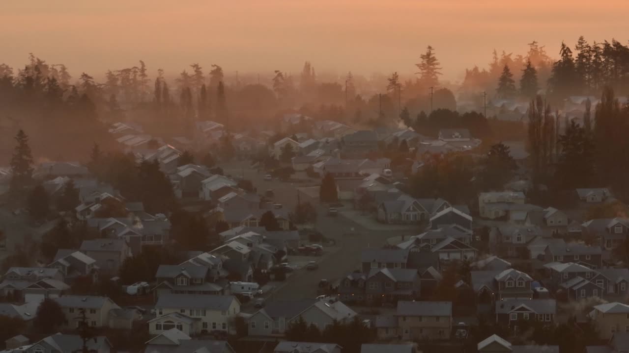 이른 아침 햇살에 안개로 둘러싸인 밀집된 동네의 공중 전망