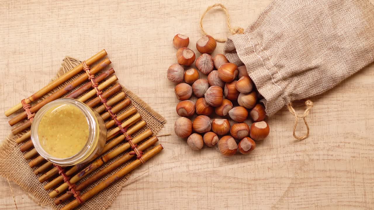 Nocciole che fuoriescono da un sacco di iuta con crema di nocciole
