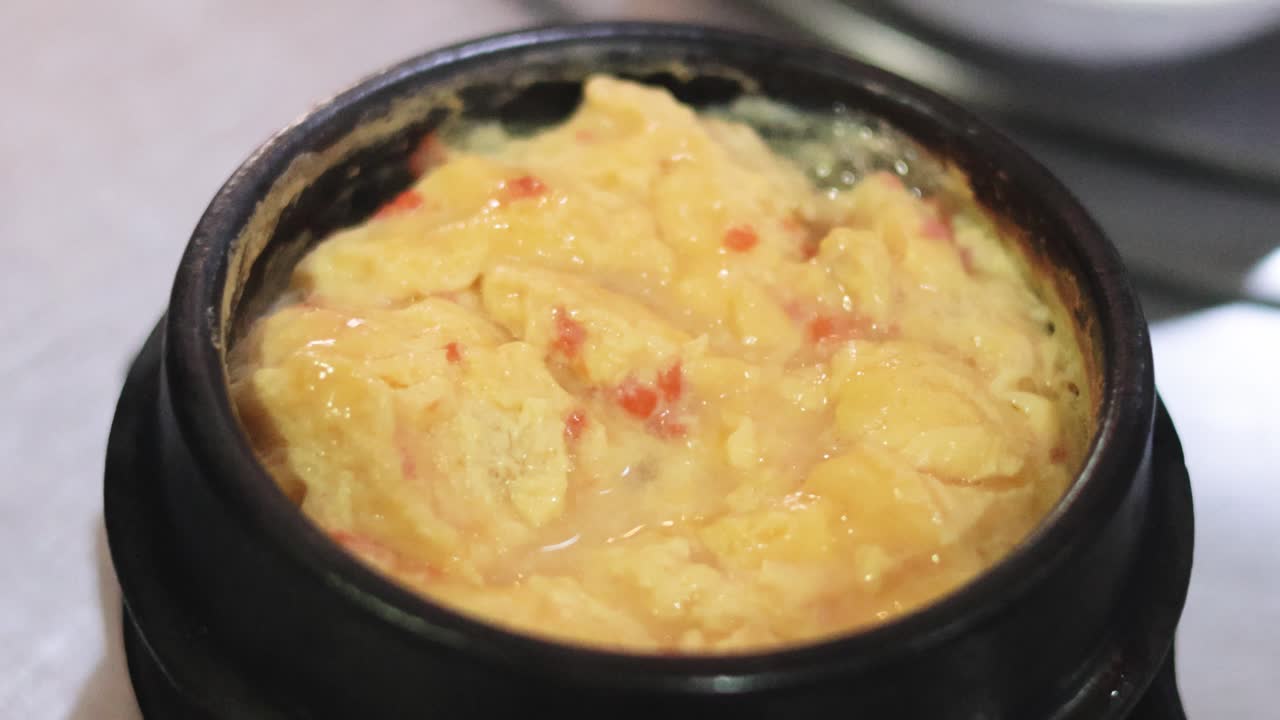 huevos revueltos cocinados en una olla negra