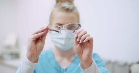 female doctor wearing protective mask on face and cleaning glasses doctor at healtcare clinic