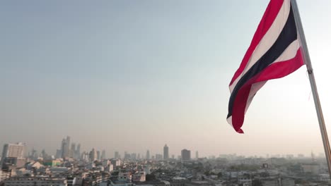 bandera de tailandia en el viento con vistas a bangkok al atardecer imágenes de 4k