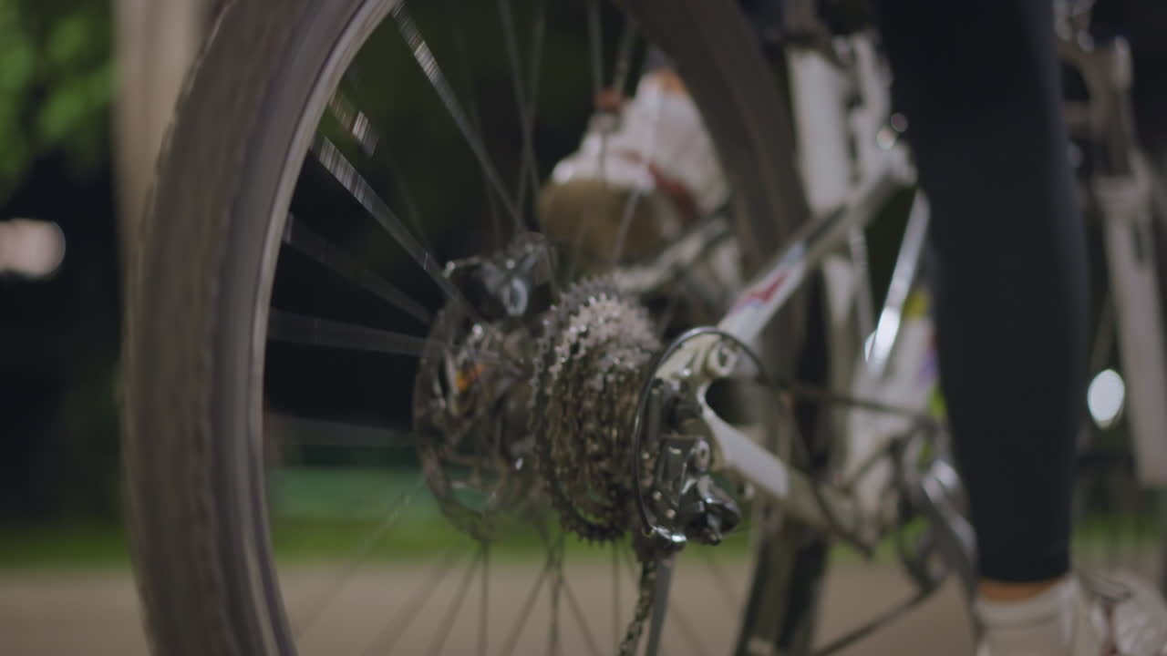 Closeup Rear Cassette And Derailleur Motion, Intricate Sprockets And Chain Shifting Under Lamplight, Mechanical Detail Showing Engineering, Grease Highlights And Precision Movement