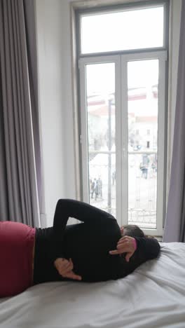 woman relaxing and stretching in a bedroom