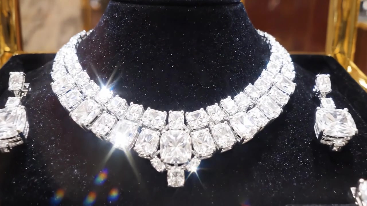 Elegante esposizione di gioielli squisiti con una splendida collana di diamanti e anelli complementari in un'ambientazione di vetrina lussuosa.
