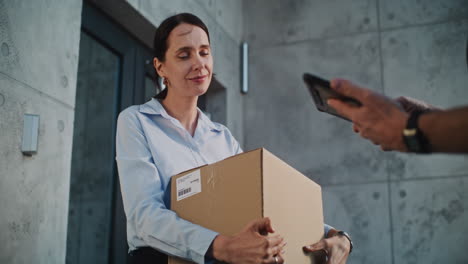 woman receives and signs for a delivered package