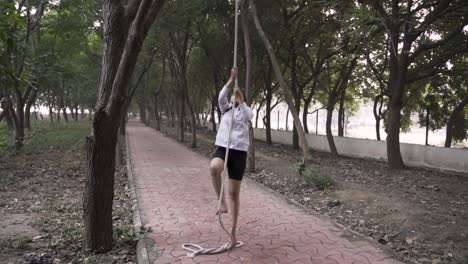 A-sporty-gymnast-performs-exercises-with-a-rope-in-sportswear