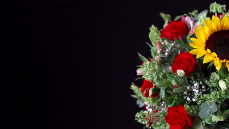 flower arrangement spinning and panning black background wide shot