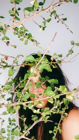 woman hidden behind branches