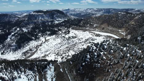 Vista-Aérea-De-Los-Picos-De-Las-Montañas-Y-La-Carretera-Escénica