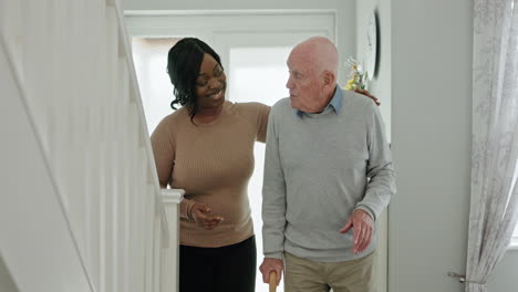 Caregiver assisting elderly man on stairs