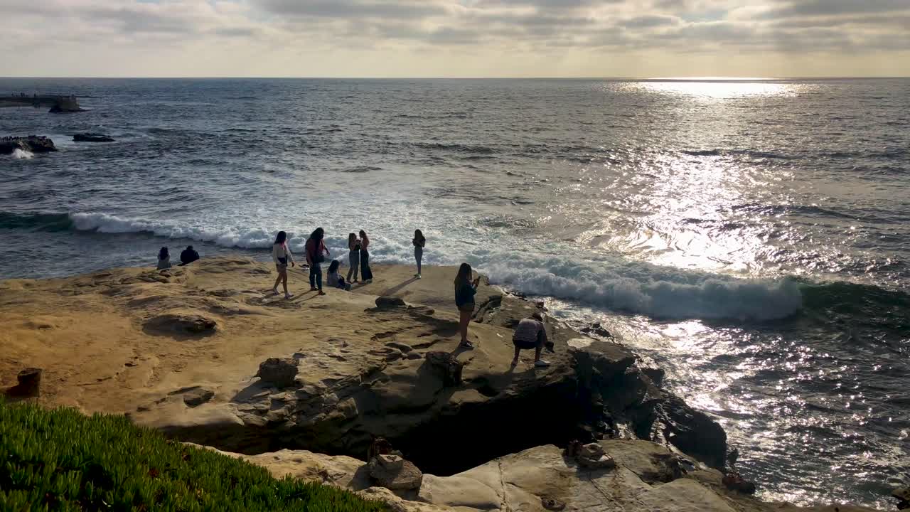 사람들은 물개 사이에서 아름다운 일몰을 즐깁니다.