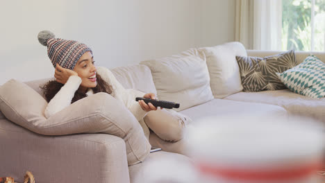mujer feliz con ropa cálida acostada en el sofá viendo televisión 4k 4k
