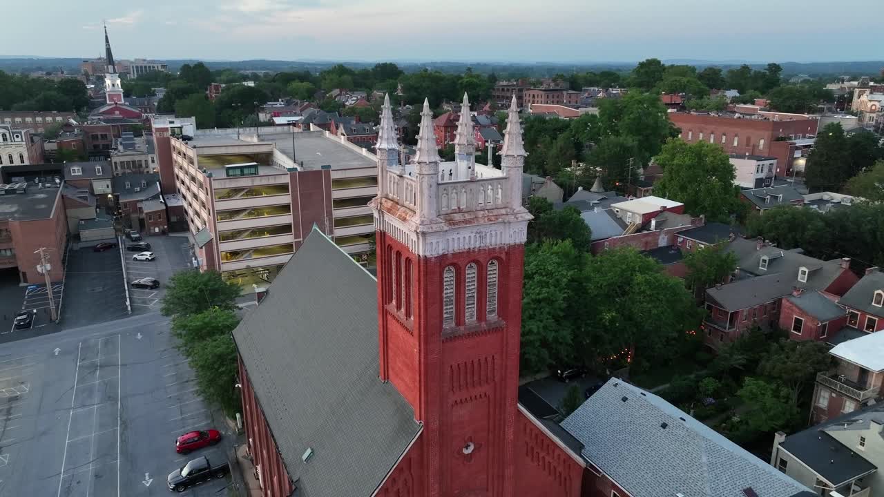 Aerial rising shot of The Lord's House of Prayer church in Lancaster, Pennsylvania. Dusk scene in summer. Car park and housing area with historic buildings
